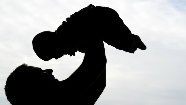 Silhouette of man with his little daughter