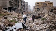 People walk amid the rubble as they carry belongings that they collected from their houses in the government controlled area of Aleppo Security Council